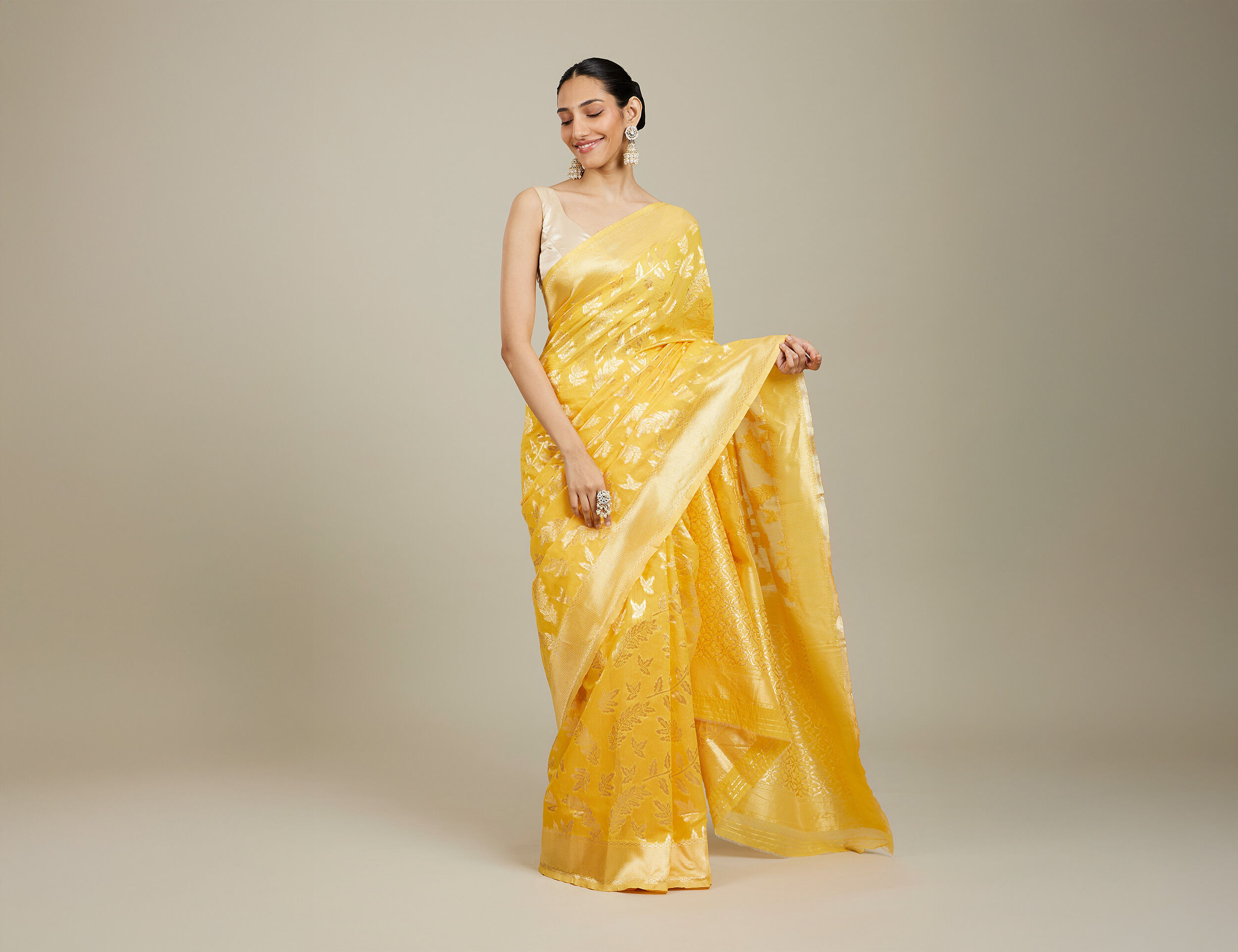 Young woman in yellow saree with floral print for pre-wedding Haldi event